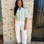 Light green patterned puff sleeve top paired with white jeans 