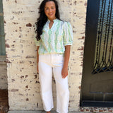 Light green patterned puff sleeve top paired with white jeans 