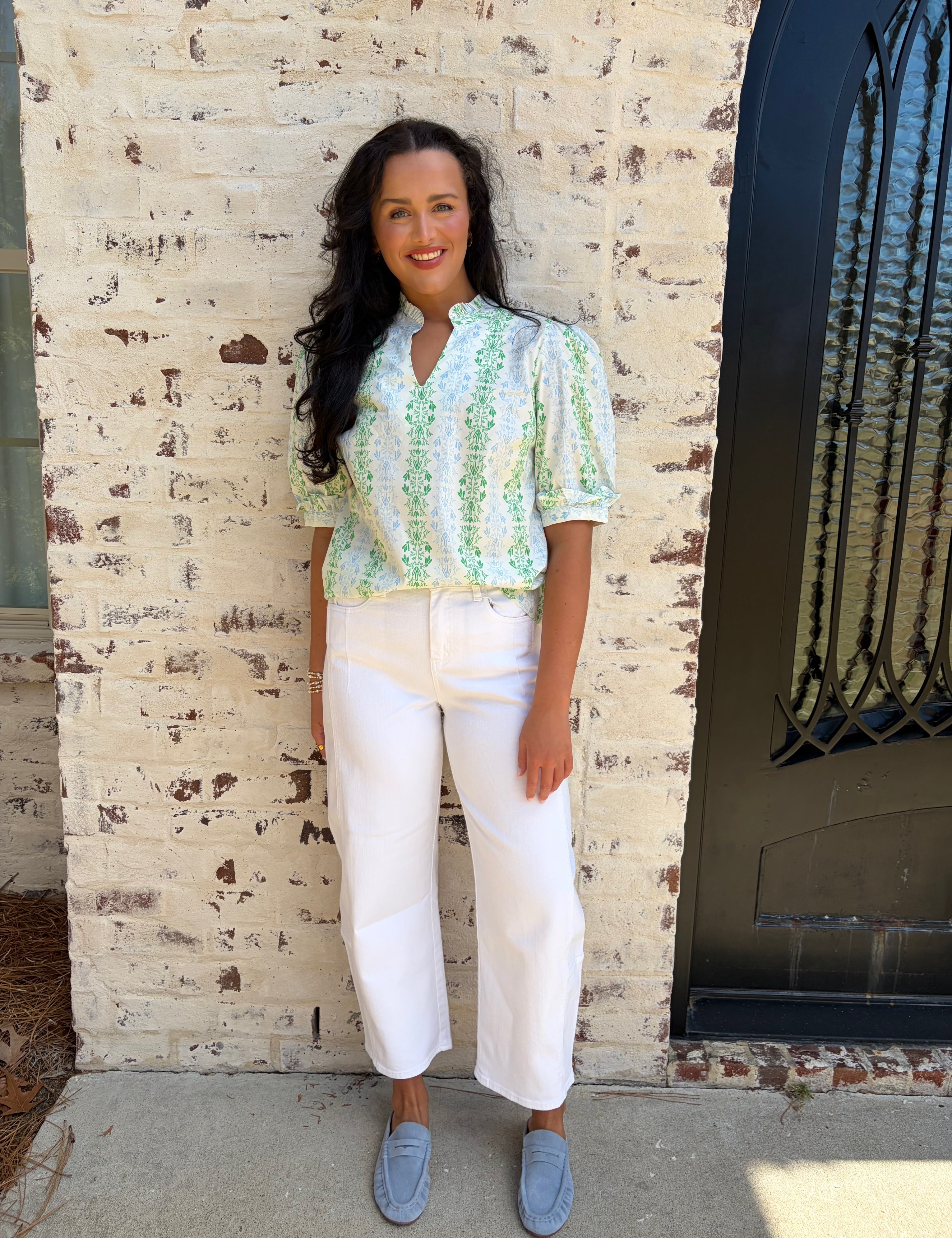 Light green patterned puff sleeve top paired with white jeans 