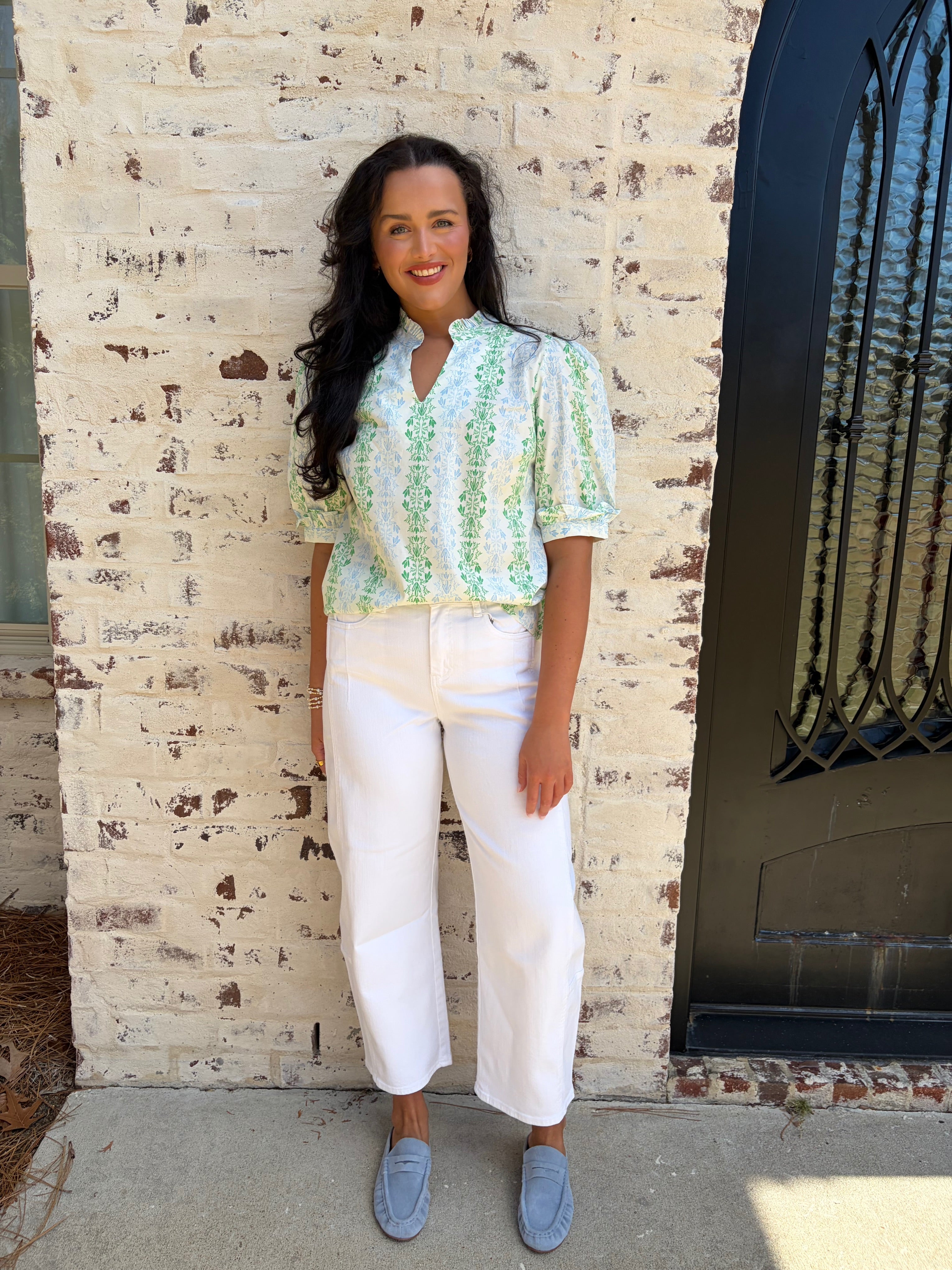 Light green patterned puff sleeve top paired with white jeans 