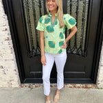 Cropped bootcut white jeans with a green floral top