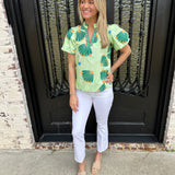 Cropped bootcut white jeans with a green floral top