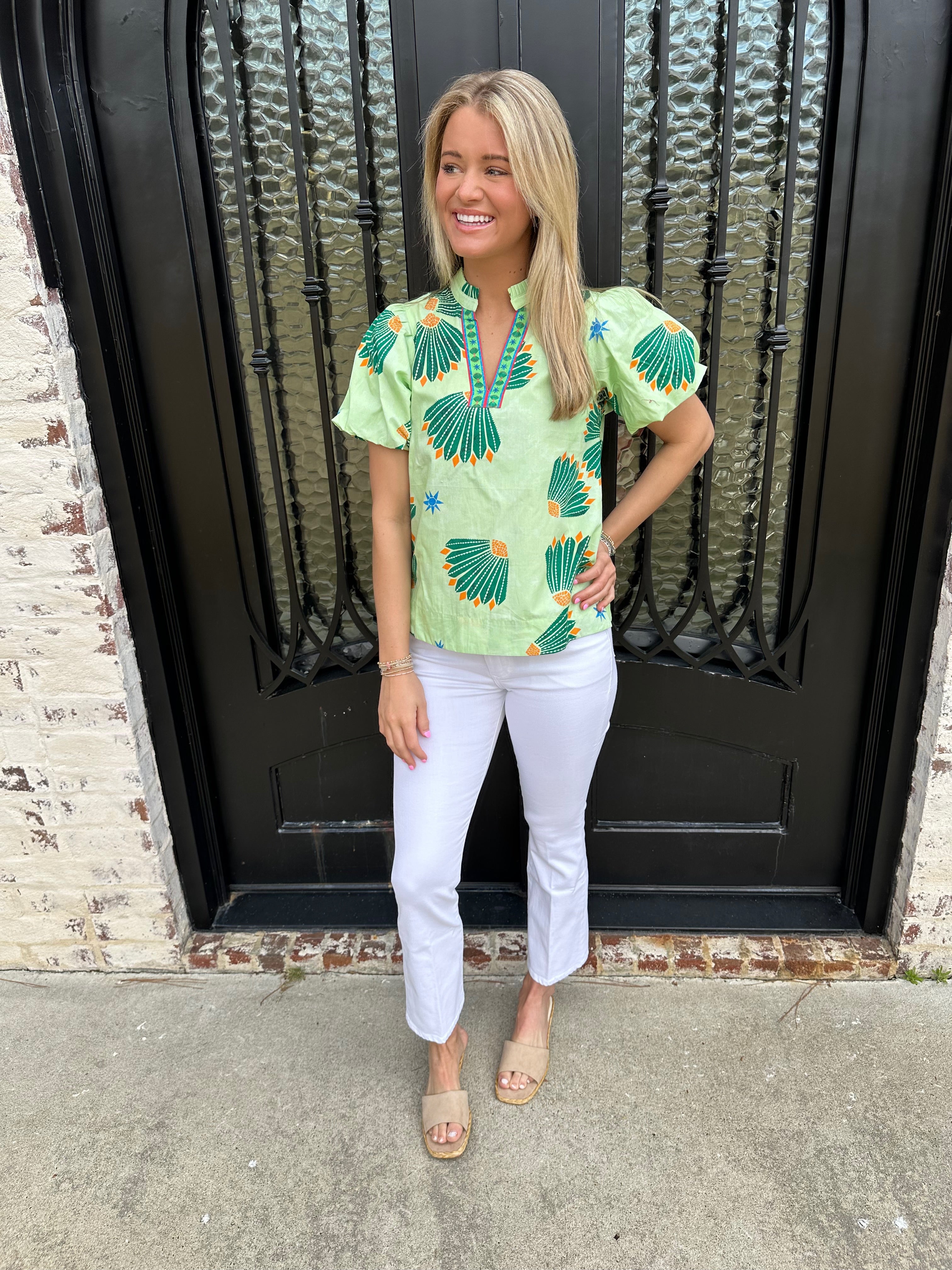 Cropped bootcut white jeans with a green floral top
